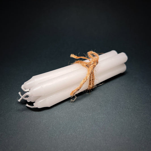 Candle set of four in white color, tied together with a thin rope.