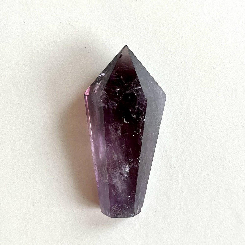 Kiillotettu ametistikärki AA-laatua, syvän violetin sävyissä ja selkeillä kvartsimuodostelmilla. - Polished AA-grade amethyst point with deep purple tones and well-defined quartz formations.