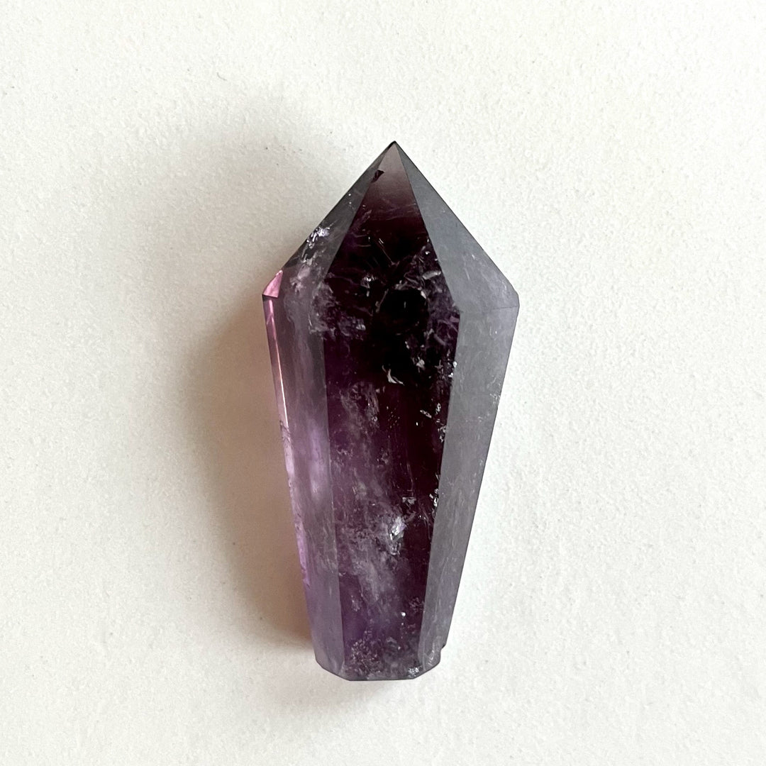 Kiillotettu ametistikärki AA-laatua, syvän violetin sävyissä ja selkeillä kvartsimuodostelmilla. - Polished AA-grade amethyst point with deep purple tones and well-defined quartz formations.