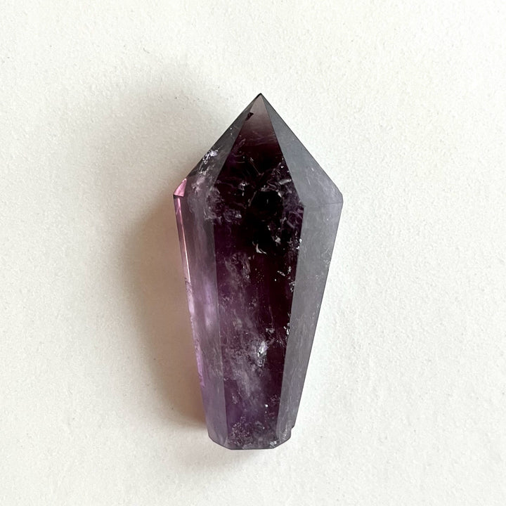 Kiillotettu ametistikärki AA-laatua, syvän violetin sävyissä ja selkeillä kvartsimuodostelmilla. - Polished AA-grade amethyst point with deep purple tones and well-defined quartz formations.