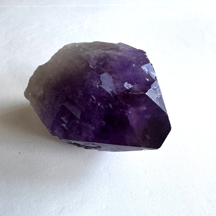 Detailed tip of amethyst cathedral quartz, with clearer crystals toward the apex symbolizing spiritual growth. - Ametisti-katedraalikvartsin kärki yksityiskohtaisesti, kirkastuvat kiteet kohti huippua, symboloiden henkistä kasvua.