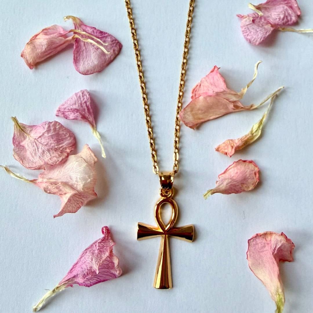 18k kullattu Ankh-kaulakoru, muinaisegyptiläinen elämän symboli pehmeiden kukkien keskellä - 18k gold plated Ankh necklace, ancient Egyptian symbol of life, styled with soft flower petals