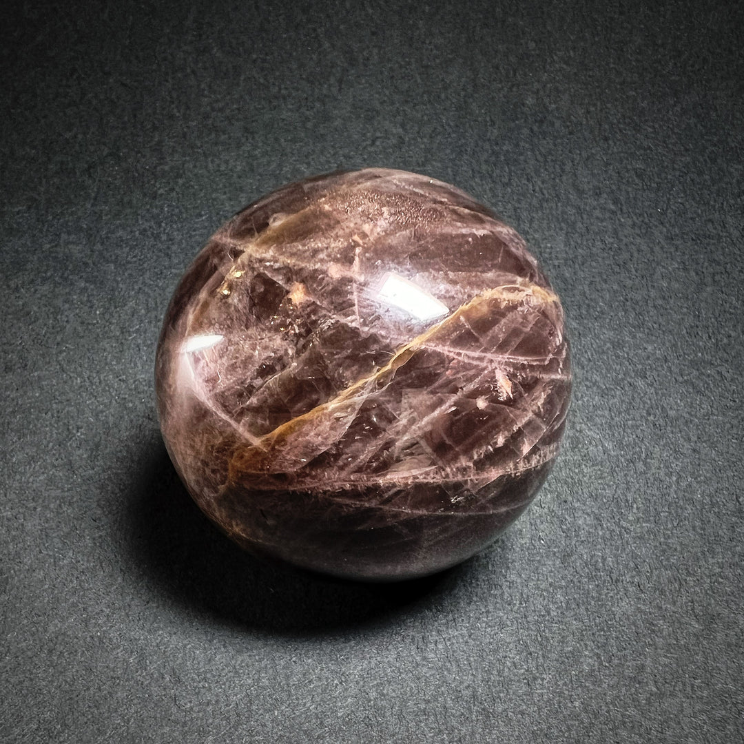 Musta kuukivi hiottuna pallon muotoon - Black moonstone carved to a sphere shape.