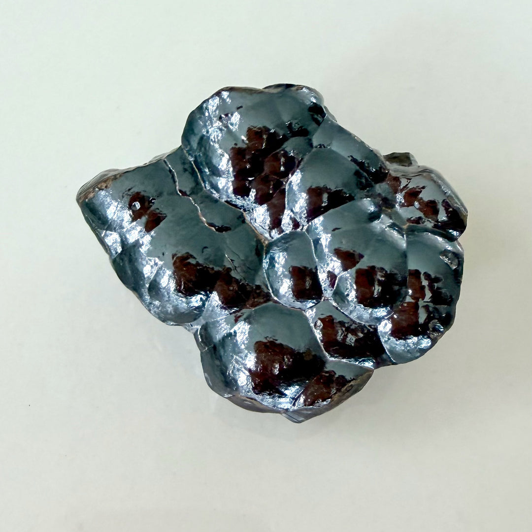 Botryoidinen hematiitti – rypälemäinen raakakivi, jossa tummanharmaa metallinkiilto ja sileä, kumpuileva pinta. -  Botryoidal hematite – raw mineral specimen with dark metallic luster and smooth, rounded surface.
