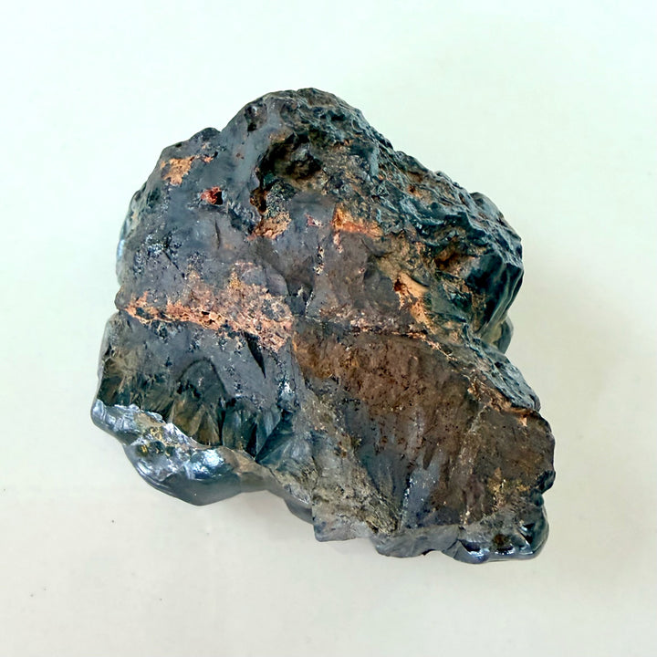 Botryoidinen hematiitti pohjasta kuvattuna, tummanharmaa peruskiven rakenne. - Botryoidal hematite viewed from the bottom, showing its dark-grey texture.