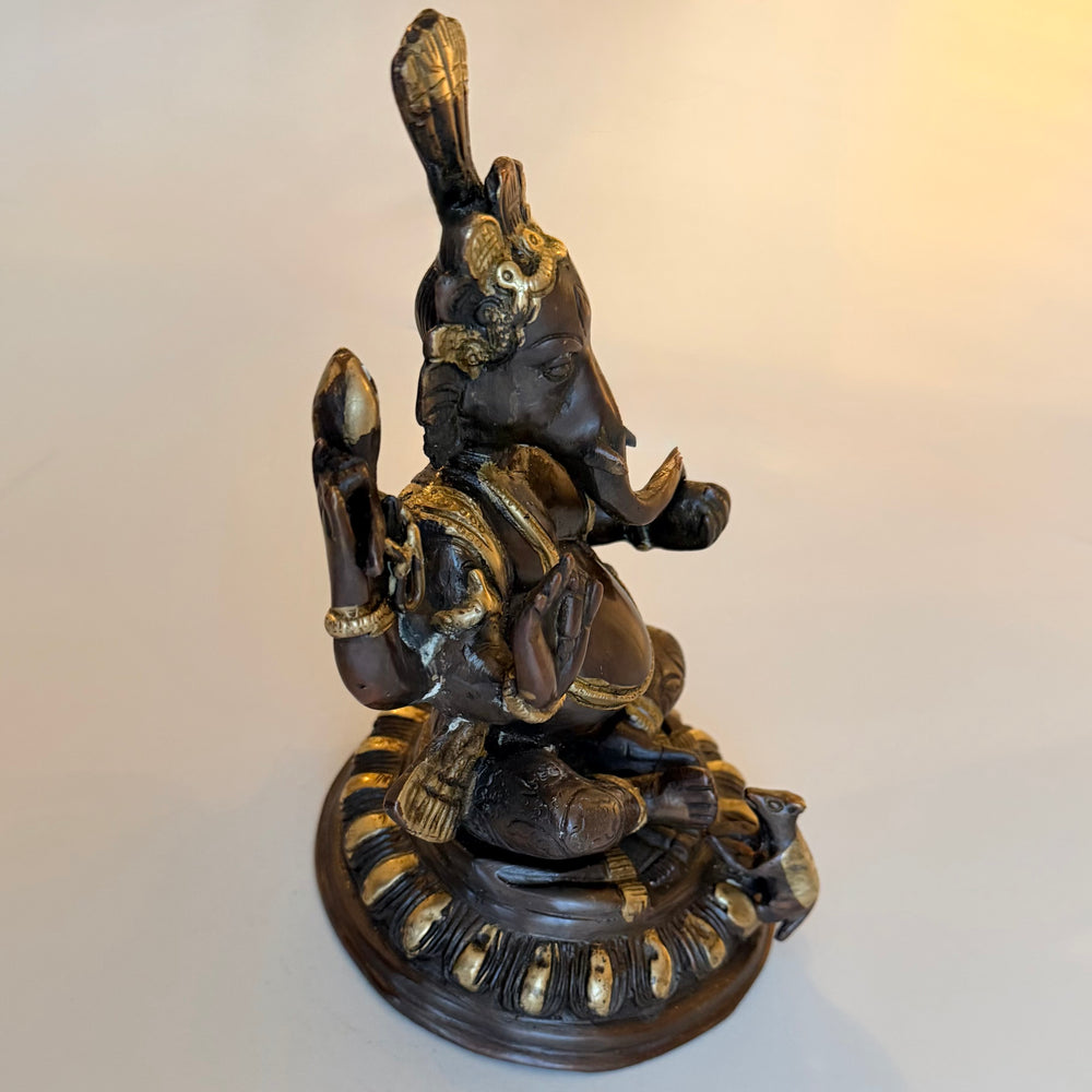 Ganesha-patsas oikealta sivulta, perinteisellä hiekkavalutekniikalla valmistettu vintage-esine - Right side view of a vintage Ganesha statue made using traditional sand casting.