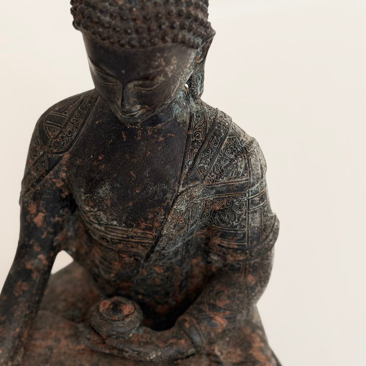 Buddha-patsaan ylävartalo viistosta kuvattuna; rauhalliset kasvonpiirteet ja koristeltu kaapu. - Angled view of the upper body of the Buddha statue, featuring serene facial features and an ornamented robe.
