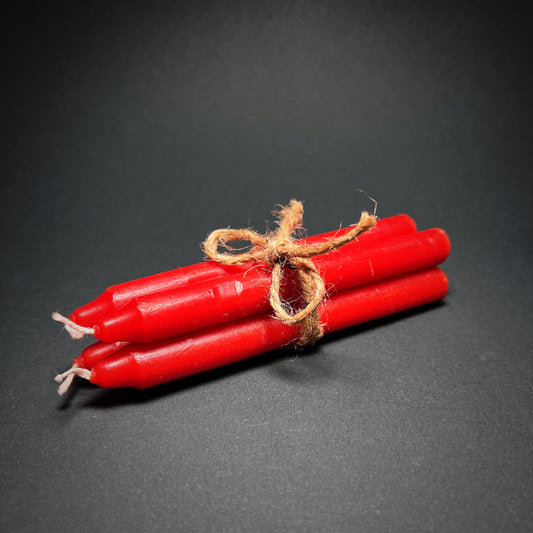 Candle set of four in red color, tied together with a thin rope.
