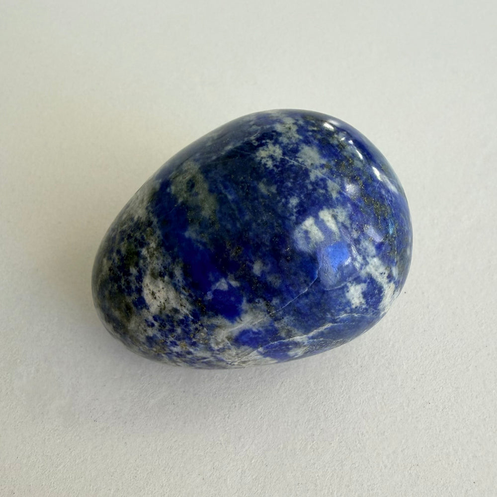 Lapis lazuli -muna, syvänsininen kivi jossa valkoista kalsiittia ja kultahohtoista pyriittiä
Lapis lazuli egg with deep blue lazurite, white calcite and golden pyrite inclusions