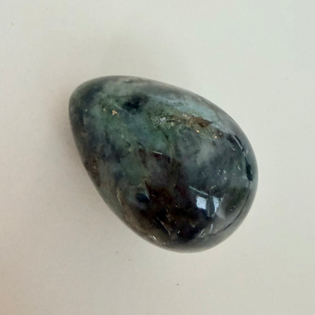 Kiillotettu labradoriittimuna, harmaa perusväri ja sinertävä valonvälke, koko noin 5 cm.
Polished labradorite egg with grey base color and blue light flash, approximately 5 cm in size.