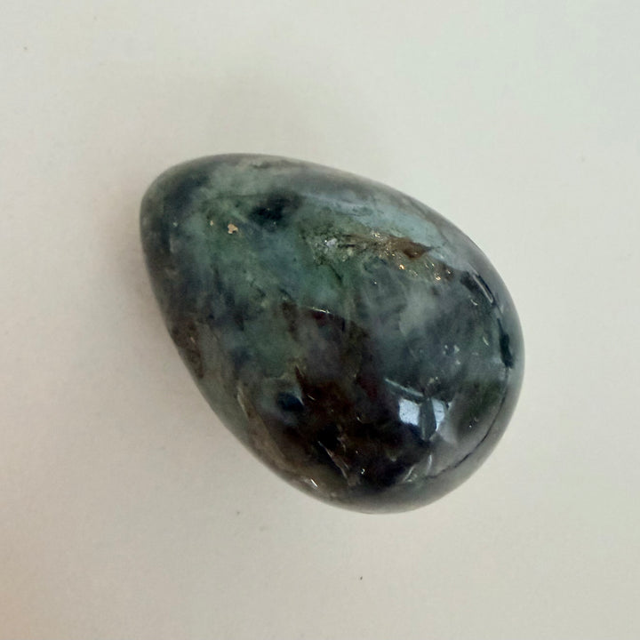 Kiillotettu labradoriittimuna, harmaa perusväri ja sinertävä valonvälke, koko noin 5 cm.
Polished labradorite egg with grey base color and blue light flash, approximately 5 cm in size.