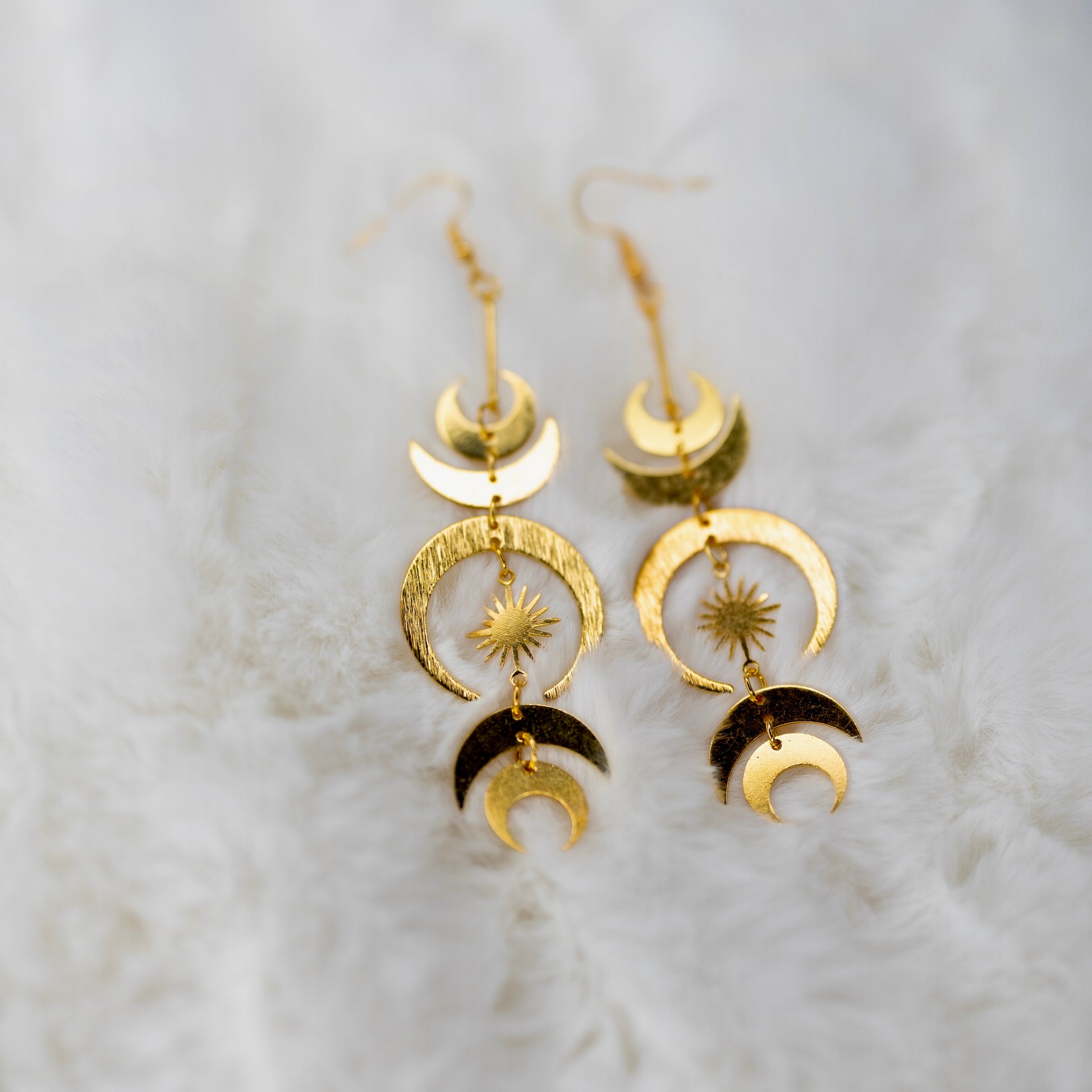 Pitkät kultaiset korvakorut, joissa on kuun ja tähtien symboliikkaa - Long gold earrings with moon and star symbolism