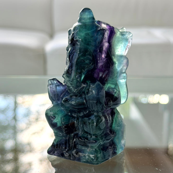 Lähikuva fluoriitti Ganesha -patsaasta, jossa norsupäinen hahmo näkyy sinivihreän ja violetin läpikuultavan kiven sisällä.