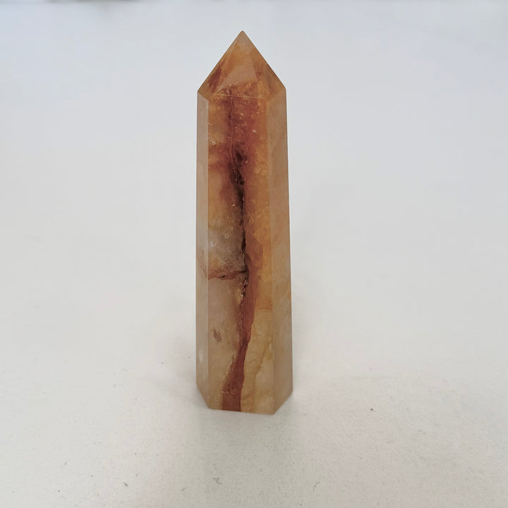 Golden healer -kvartsitorni, jossa kultainen rautaoksidivärjäytymä kirkkaan kvartsin pinnalla
Golden healer quartz tower with golden iron oxide coloration on clear quartz surface