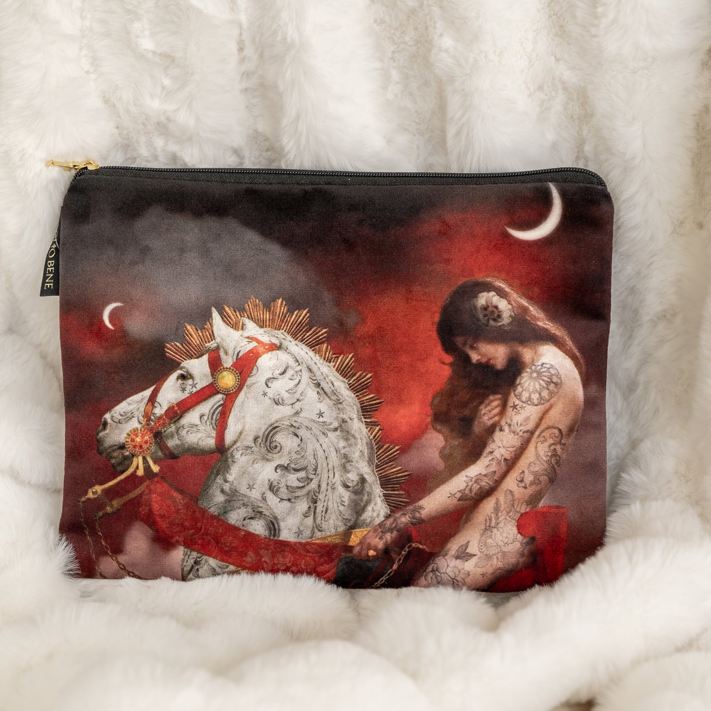 Kuva samettisesta pussukasta, jossa on valkoisen hevosen ja Lady Godivan painatus. - Image of a velvet pouch featuring a print of a white horse and Lady Godiva.