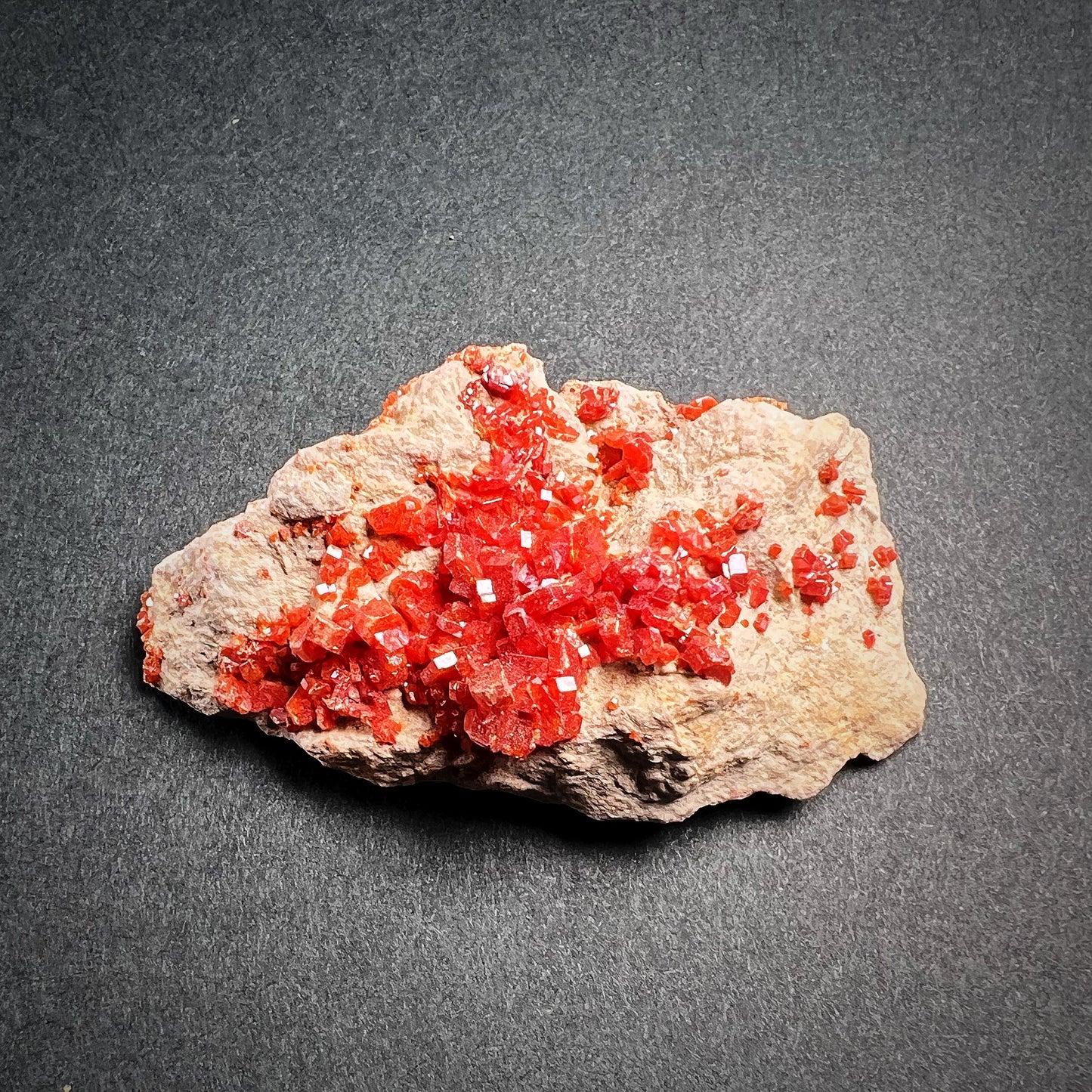Pieni vanadiniittikristalliklusteri kiinnittyneenä pohjakiveen - Small vanadinite crystal cluster in matrix stone