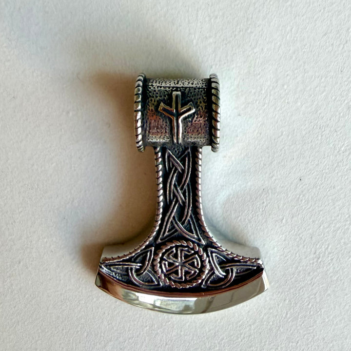 Thorin vasaran muotoinen ruostumattomasta teräksestä valmistettu amuletti lähikuvassa.