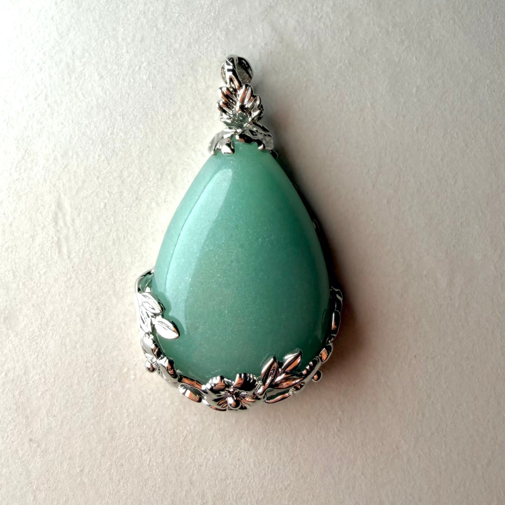 FI: Pisaranmuotoinen vihreä aventuriiniriipus hopeisella kukkakoristeisella kehyksellä.
EN: Teardrop-shaped green aventurine pendant with floral silver setting.