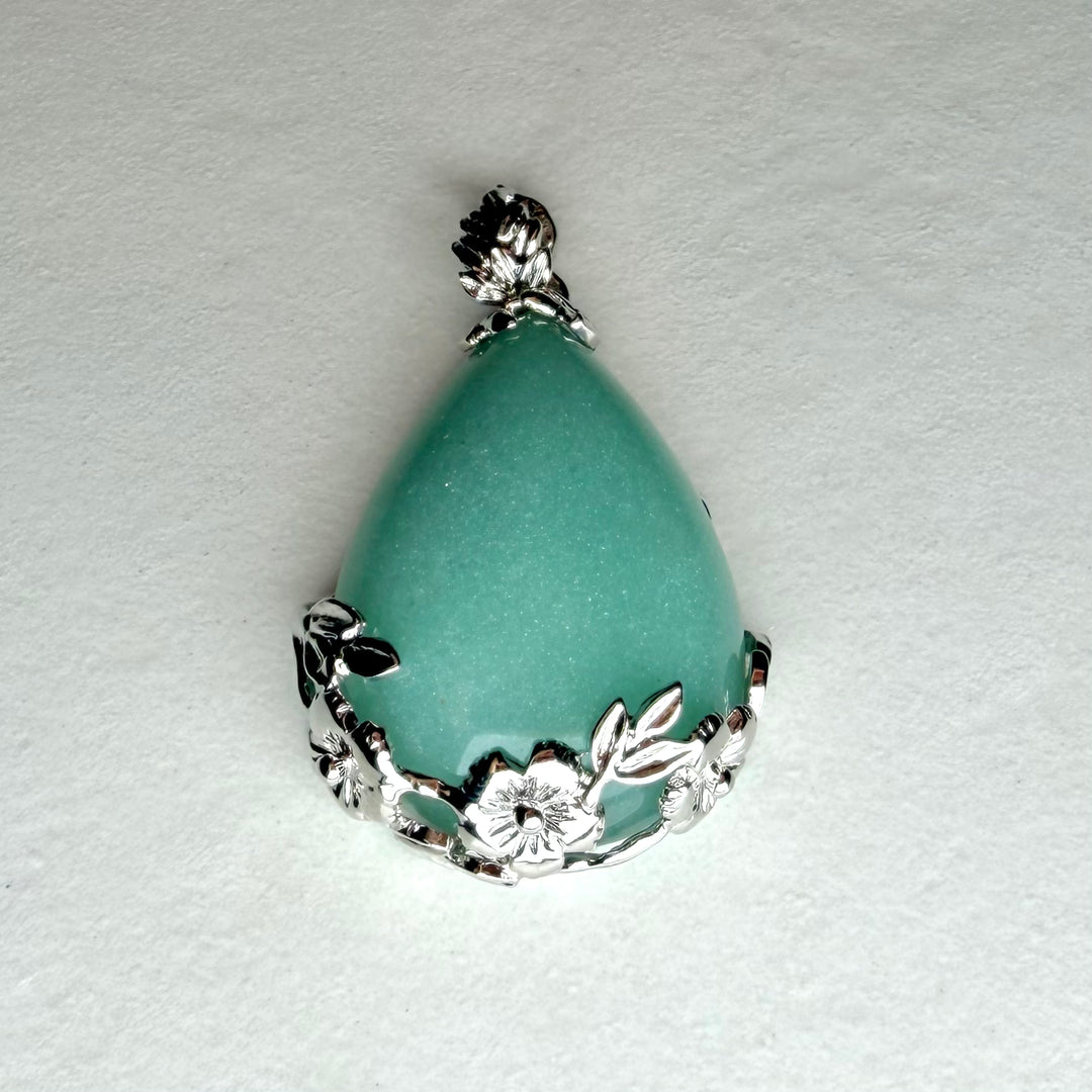 FI: Pisaranmuotoinen vihreä aventuriiniriipus hopeisella kukkakoristeisella kehyksellä.
EN: Teardrop-shaped green aventurine pendant with floral silver setting.