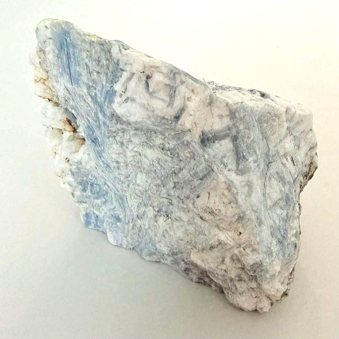 FI: Sininen säikeinen kyaniitti kvartsin ja maasälvän muodostamassa kivessä, 608 g raakapala.
EN: Blue fibrous kyanite in quartz matrix, 608 g rough specimen.