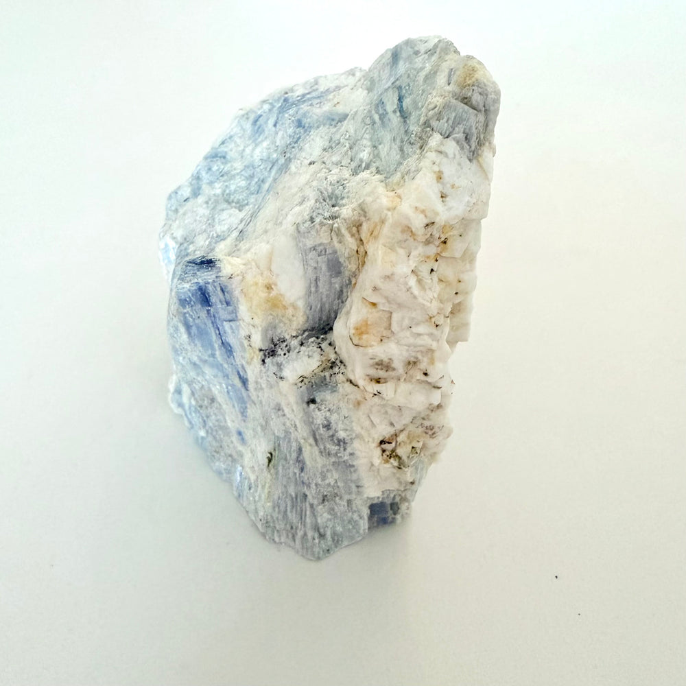FI: Sininen säikeinen kyaniitti kvartsin ja maasälvän muodostamassa kivessä, 608 g raakapala.
EN: Blue fibrous kyanite in quartz matrix, 608 g rough specimen.