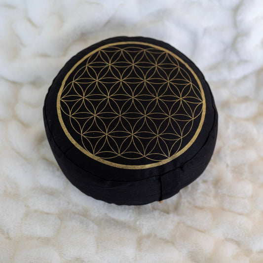 Meditaatiotyyny Flower of Life, musta/kulta, ylhäältä kuvattuna, joka näyttää sen pyöreän muodon ja Flower of Life -symbolin. - Meditation cushion Flower of Life, black/gold, top view showing its round shape and the Flower of Life symbol.