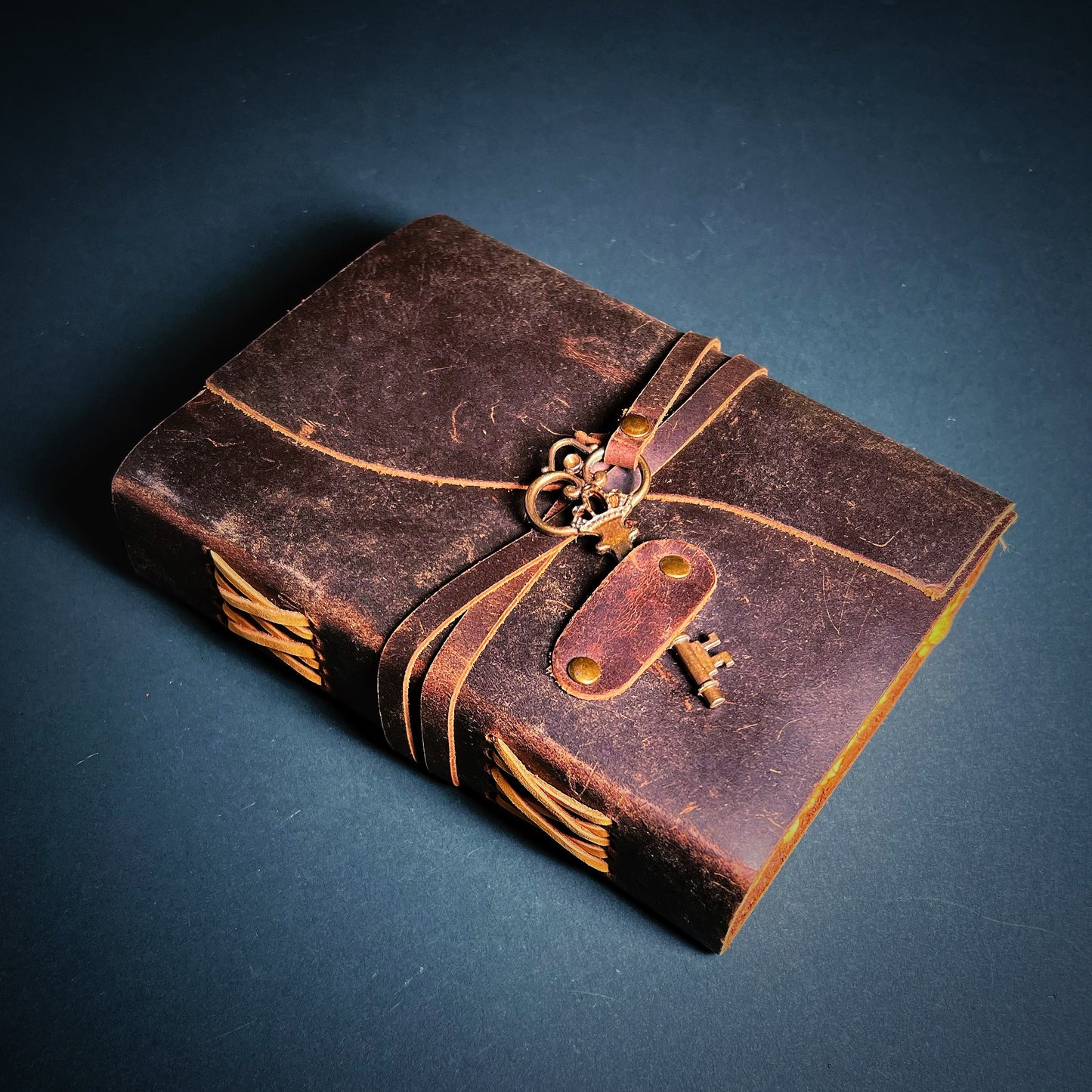 Old-fashioned notebook with brown leather covers and a locket