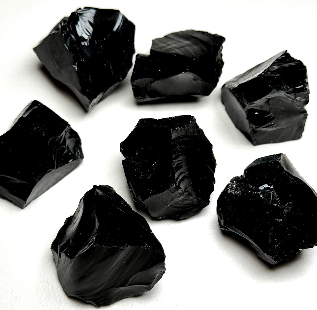 Obisidiaanikristallin raakapaloja valkoisella taustalla - Obsidian crystal rough pieces on a white background.