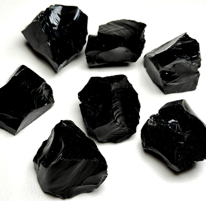 Obisidiaanikristallin raakapaloja valkoisella taustalla - Obsidian crystal rough pieces on a white background.