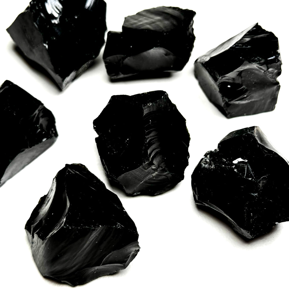 Obisidiaanikristallin raakapaloja valkoisella taustalla - Obsidian crystal rough pieces on a white background.