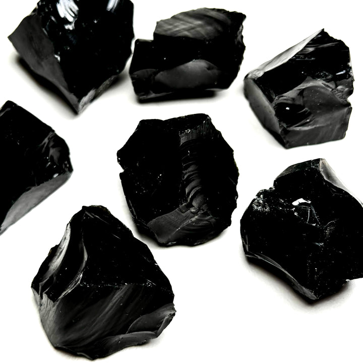 Obisidiaanikristallin raakapaloja valkoisella taustalla - Obsidian crystal rough pieces on a white background.