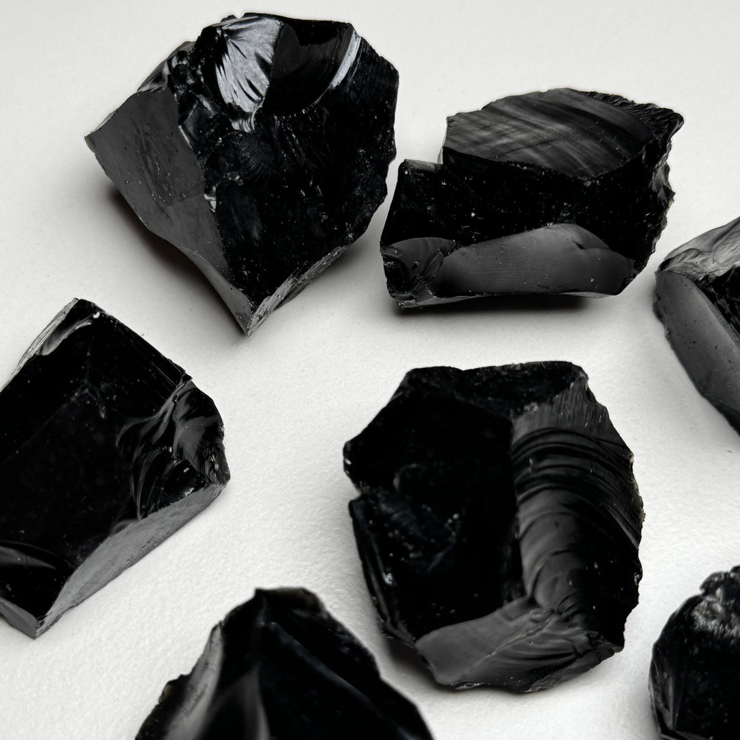 Obisidiaanikristallin raakapaloja valkoisella taustalla - Obsidian crystal rough pieces on a white background.