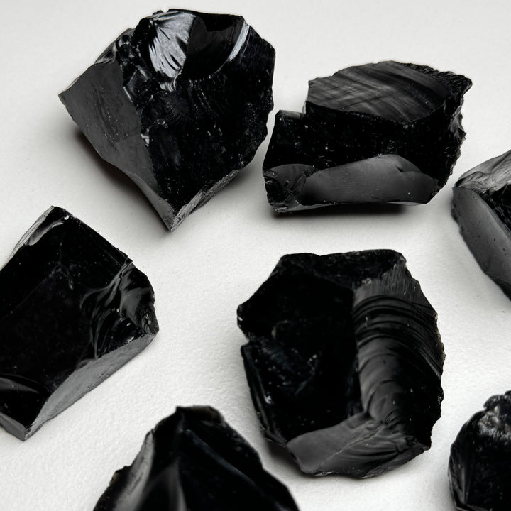 Obisidiaanikristallin raakapaloja valkoisella taustalla - Obsidian crystal rough pieces on a white background.