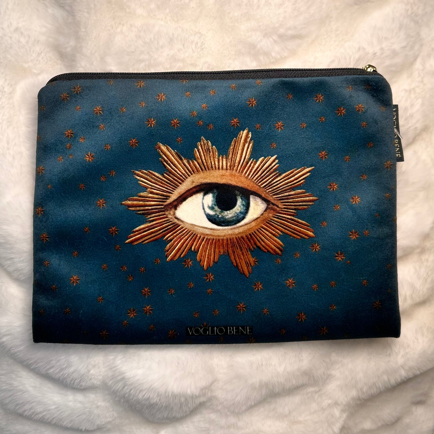 One Against Being -samettipussukan takapuoli, jossa silmä ja sitä ympäröivät kultaiset säteet symboloivat oivallusta ja valoa. - Back view of the One Against Being velvet pouch by Voglio Bene, showcasing a single eye surrounded by golden rays, symbolizing insight and illumination.