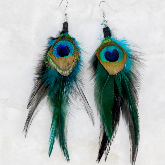 Riikinkukonsulkaiset korvakorut, joissa sulka ja metalliset yksityiskohdat. Symboloi kauneutta, ylpeyttä ja uudistumista. - Peacock feather earrings with a feather and metallic details. Symbolizes beauty, pride, and renewal.