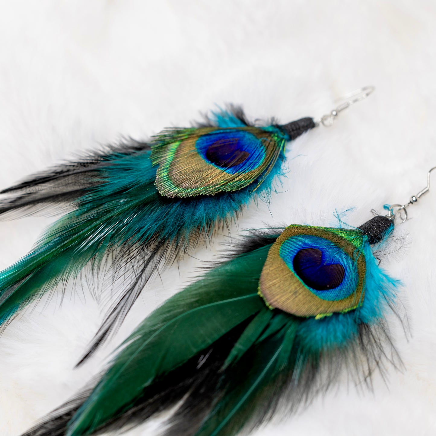 Lähikuva riikinkukon sulan silmästä, jossa näkyvät sen upeat sinisen ja vihreän sävyt. -  Close-up of the peacock feather's eye, showcasing its stunning blue and green hues.