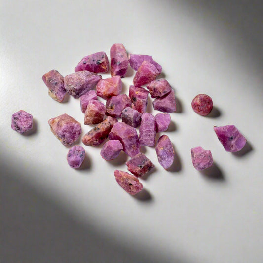 Raakarubiinin kiteitä jään päällä - Raw ruby crystals on an ice cube.