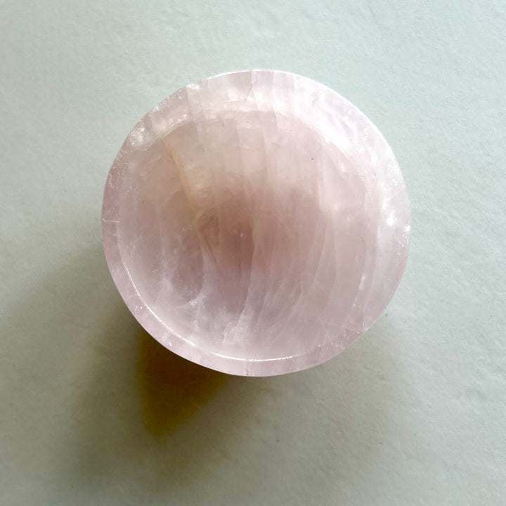 Ruusukvartsista kaiverrettu kaunis vaaleanpunainen kristalikuppi. Kuva suoraan yläpuolelta.