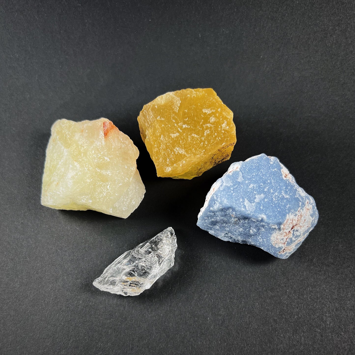 Crystal grid of four raw stones: fluorite, sulphur quartz, quartz and angelite.