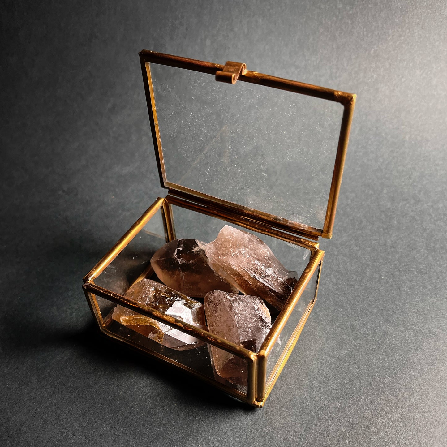 Smoky quartz points, set of four in a glass box.