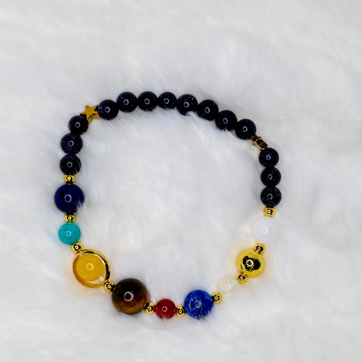 Solar System -rannekoru luonnonkivistä, jossa jokainen kivi edustaa aurinkokuntamme planeettoja. Avaruusteemainen rannekoru. - Solar System bracelet made of natural stones, each representing a planet in our solar system. Space-themed bracelet.