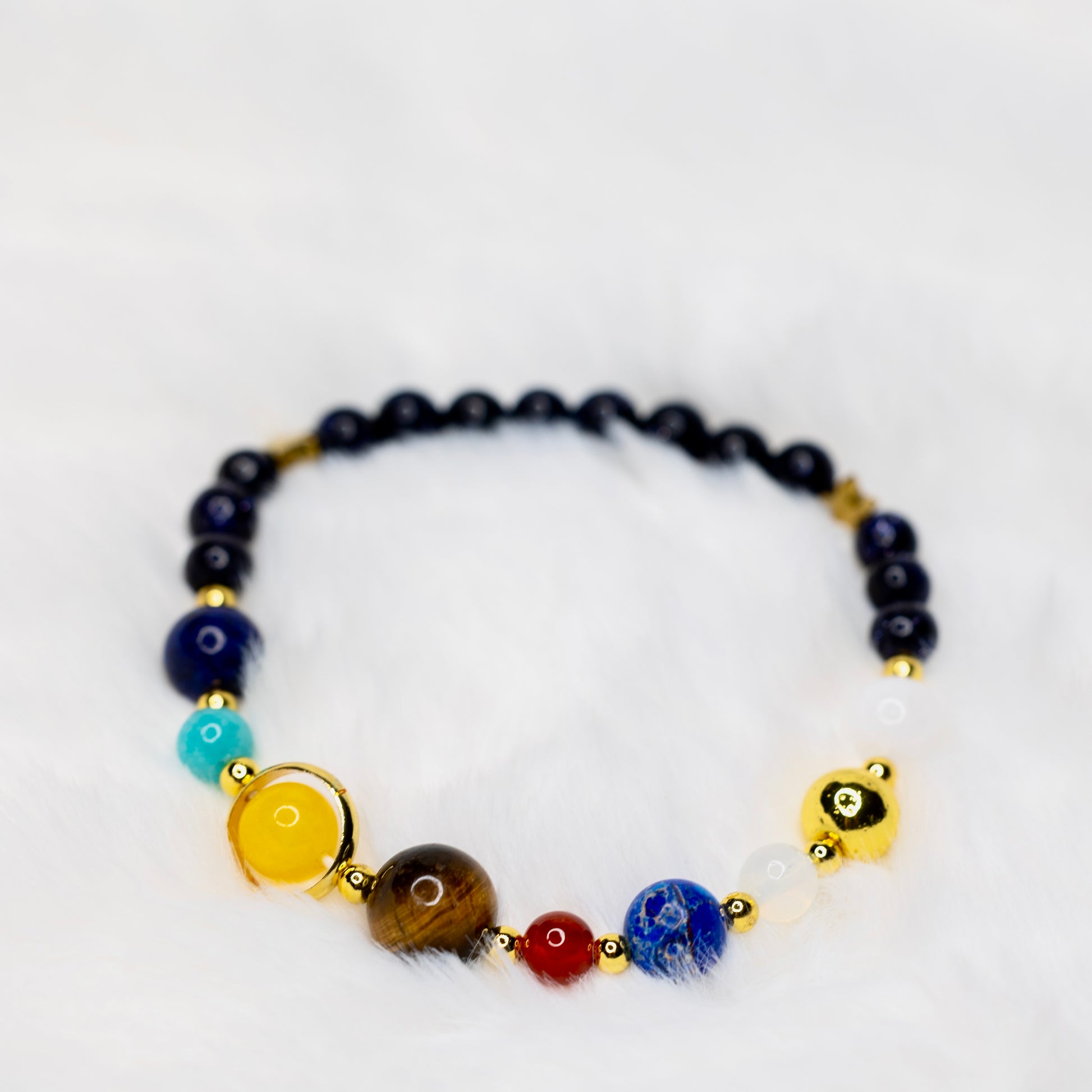 Solar System -rannekoru luonnonkivistä, jossa jokainen kivi edustaa aurinkokuntamme planeettoja. Avaruusteemainen rannekoru. - Solar System bracelet made of natural stones, each representing a planet in our solar system. Space-themed bracelet.