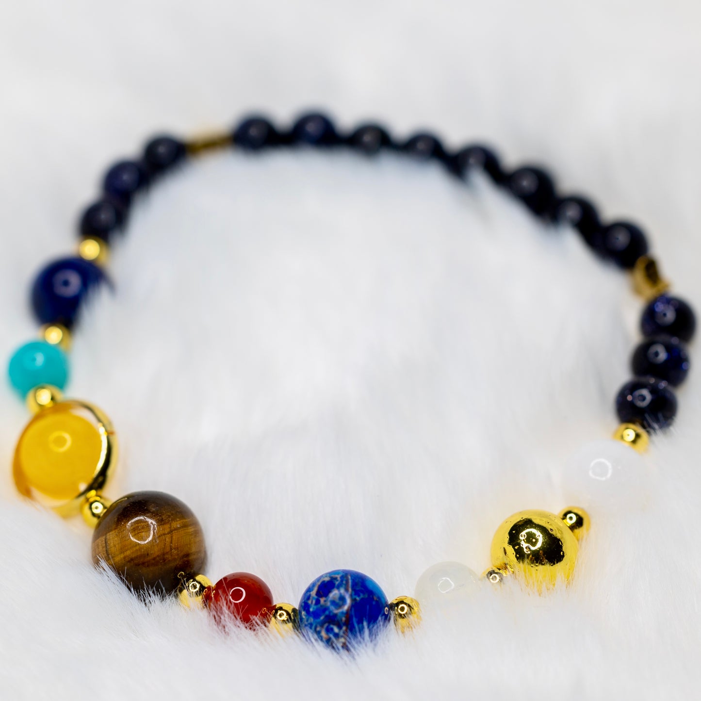 Solar System -rannekoru luonnonkivistä, jossa jokainen kivi edustaa aurinkokuntamme planeettoja. Avaruusteemainen rannekoru. - Solar System bracelet made of natural stones, each representing a planet in our solar system. Space-themed bracelet.