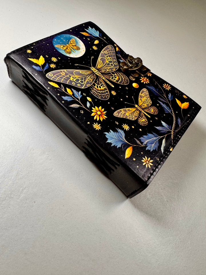 Nahkakantinen The Golden Butterfly -muistikirja kuvattuna viistosti, esillä käsityön yksityiskohdat. - The Golden Butterfly leather notebook captured from an angle, highlighting fine craftsmanship details.