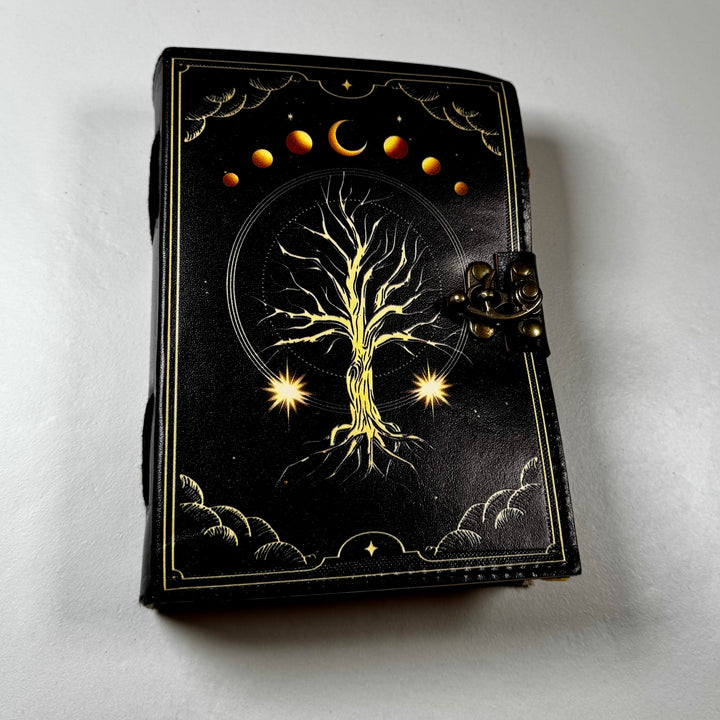The Tree of Life -muistikirjan etukansi, jossa puusymboli ja koristeellinen kohokuviointi. - Front cover of The Tree of Life notebook featuring a tree symbol and embossed decorative details.