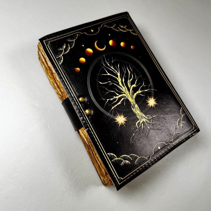 Elämänpuu-aiheinen nahkakantinen muistikirja takaa kuvattuna, esillä kirjan takakansi. - Tree of Life-themed leather-bound notebook photographed from the back, showing the book’s back cover.