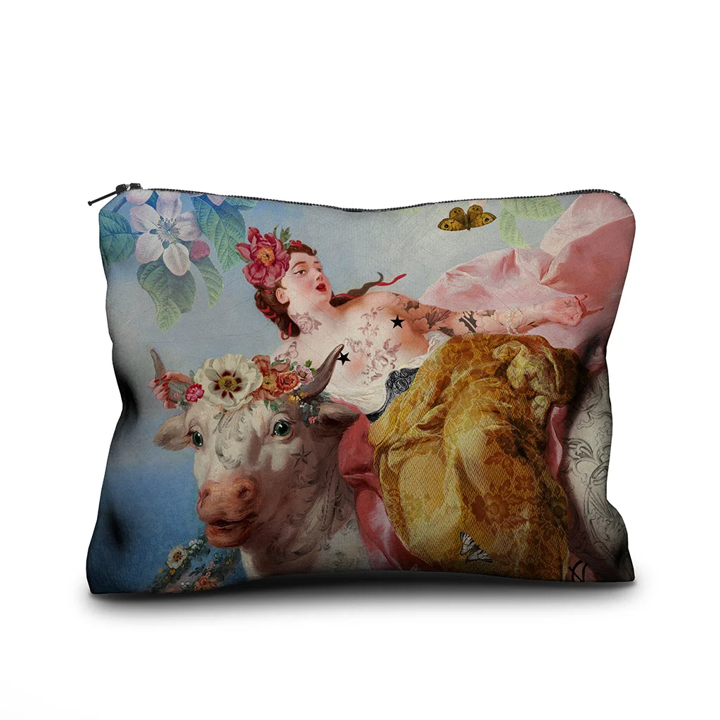 Voglio Bene Cow -samettipussukan etunäkymä, koko 17 × 23 cm, jossa lehmä ja tatuoitu nainen on kuvattu yhdessä kukkaornamentein koristeltuna.
Front view of a Voglio Bene Cow velvet pouch, size 17 × 23 cm, showing a cow together with a tattooed woman adorned with floral ornaments.