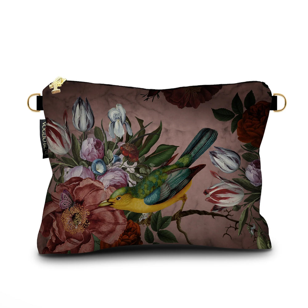 Kuvassa Voglio Bene samettilaukun takapuoli Black Beauty -kuvituksella, jossa lintu istuu suurella kukalla pinkillä taustalla.
In the image, the back side of a Voglio Bene velvet bag with the Black Beauty illustration, showing a bird perched on a large flower against a pink background.