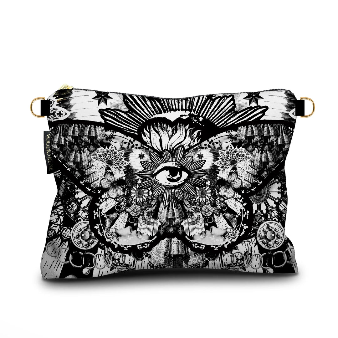 Kuvassa Voglio Bene -samettilaukun takapuoli Black Butterfly -kuvituksella. Mustavalkoisella tyylillä kuvattu suuri perhonen, jonka siipien kuvioissa näkyy silmiä ja aurinkoja.
The back of the Voglio Bene velvet bag with Black Butterfly illustration. A large butterfly in black and white tattoo style with eyes and suns forming the patterns on its wings.