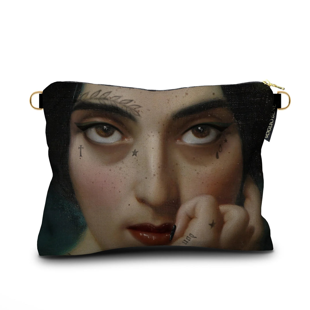 Kuvassa Voglio Bene samettilaukun takapuoli Clementine -kuvituksella, jossa näkyy lähikuva naisen silmistä.
In the image, the back side of a Voglio Bene velvet bag with the Clementine illustration, showing a close-up of the woman’s eyes.